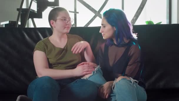 Portrait of lesbian couple looking into the camera. Two happy girlfriends. A girl with colored hair and a bald woman hold hands. Free same-sex love. Homosexual relationship. LGBT Community Pride. — Stock Video
