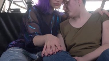 Kanepede sarılan iki lezbiyen. Siyah saçlı bir kız ve kel bir kadın el ele tutuşuyor. Bedava eşcinsel aşkı. Homoseksüel ilişki. Lgbt Topluluk Gururu Konsepti.