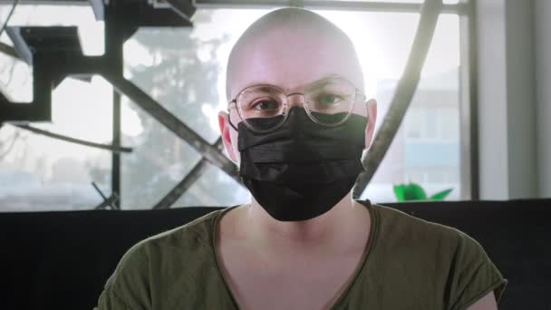 Glatzkopf ist an Krebs erkrankt. Frau setzt medizinische Schutzmaske auf. Schützt vor dem chinesischen Coronavirus. Rehabilitation nach Chemotherapie. Hiv ist infiziert. Coronavirus-Pandemie — Stockvideo