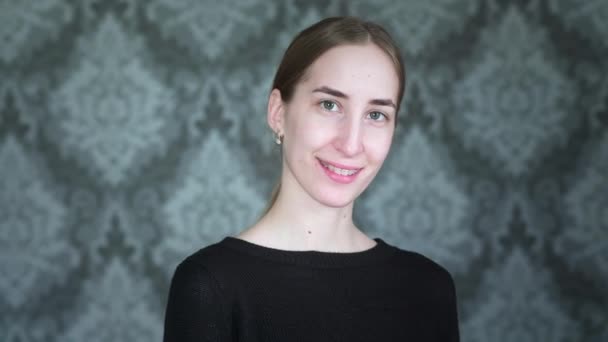 Portrait: A young girl with braces is looking at the camera. Teeth alignment and jaw correction. Mouth care. Young female with braces on teeth looking at camera and smiling — Stock Video