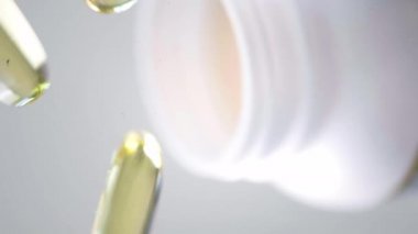 Omega 3 altın balık yağı kapsülleri, dönüşümlü arka plan. Beyaz arka planda izole kapsüller ve bulanık arka planda birçok kapsül. Yakın çekim, yüksek çözünürlüklü ürün. Sağlık hizmeti kavramı.