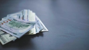 Birçok Amerikan doları yavaşça masaya düşüyor. Adam yeşil Amerikan parası saçıyor. Amerikan finans sistemi