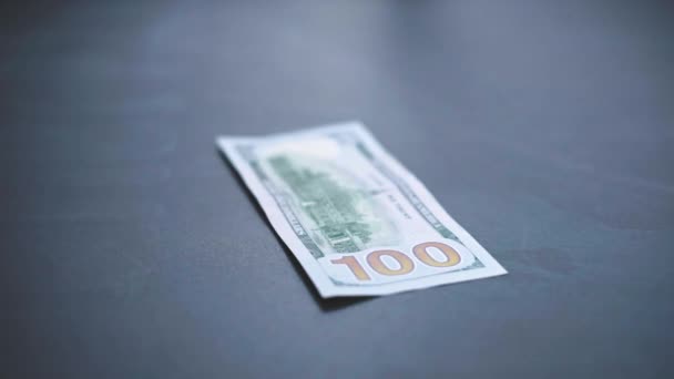 Beaucoup de dollars américains tombent lentement sur la table. L'homme jette de l'argent vert américain. Système financier américain — Video