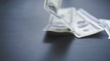 Birçok Amerikan doları yavaşça masaya düşüyor. Adam yeşil Amerikan parası saçıyor. Amerikan finans sistemi