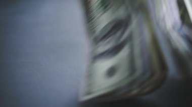 Düşen Dolarlar banknotları. Yüksek kaliteli düşen dolar banknotları. Birçok Amerikan doları yavaşça masaya düşüyor. Adam yeşil Amerikan parası saçıyor. Amerikan finans sistemi