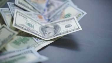 Düşen Dolarlar banknotları. Yüksek kaliteli düşen dolar banknotları. Birçok Amerikan doları yavaşça masaya düşüyor. Adam yeşil Amerikan parası saçıyor. Amerikan finans sistemi