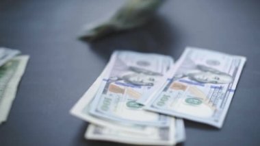 Düşen Dolarlar banknotları. Yüksek kaliteli düşen dolar banknotları. Birçok Amerikan doları yavaşça masaya düşüyor. Adam yeşil Amerikan parası saçıyor. Amerikan finans sistemi