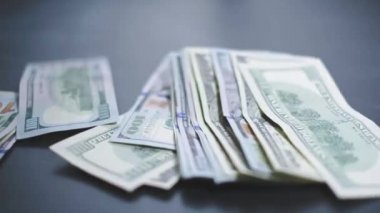 Düşen Dolarlar banknotları. Yüksek kaliteli düşen dolar banknotları. Birçok Amerikan doları yavaşça masaya düşüyor. Adam yeşil Amerikan parası saçıyor. Amerikan finans sistemi