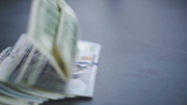 Sok amerikai dollár esik lassan az asztalra. Az ember zöld amerikai pénzt dob. Amerikai pénzügyi rendszer — Stock videók