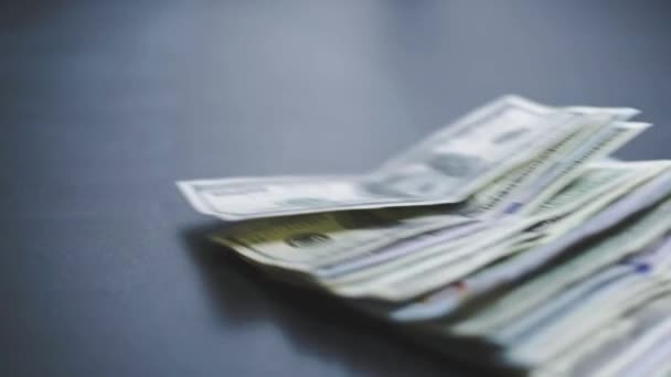 Πολλά αμερικανικά δολάρια πέφτουν σιγά-σιγά στο τραπέζι. Ο άνθρωπος πετάει πράσινα αμερικάνικα χρήματα. Οικονομικό σύστημα της Αμερικής — Αρχείο Βίντεο