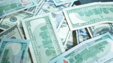 Birçok Amerikan doları dönüyor. Yeşil Amerikan parası masanın üzerinde. Amerikan finans sistemi. Paranın dönüşümlü arka planı..