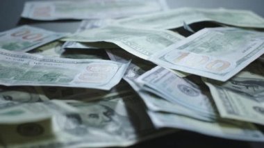 Birçok Amerikan doları dönüyor. Yeşil Amerikan parası masanın üzerinde. Amerikan finans sistemi. Paranın dönüşümlü arka planı..