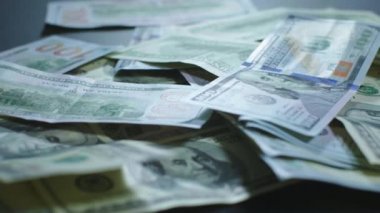 Birçok Amerikan doları dönüyor. Yeşil Amerikan parası masanın üzerinde. Amerikan finans sistemi. Paranın dönüşümlü arka planı..