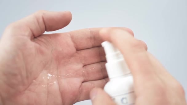 Очистка рук безводным антисептическим гелем на основе спирта. Мужчина держит бутылку для рук и наливает жидкость, альтернативу мылу для мытья рук, используемую в качестве дезинфицирующего средства для убийства бактерий — стоковое видео