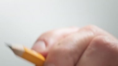 Sanatçı siyah bir kalemle düz bir çizgi çiziyor. Sanatçının elleri tahta kalem çiziyor. İşadamı kalemle not alıyor.