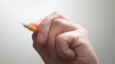 Sanatçı siyah bir kalemle düz bir çizgi çiziyor. Sanatçının elleri tahta kalem çiziyor. İşadamı kalemle not alıyor.