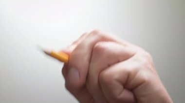 Sanatçı siyah bir kalemle düz bir çizgi çiziyor. Sanatçının elleri tahta kalem çiziyor. İşadamı kalemle not alıyor.