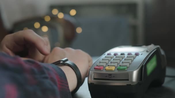 한 남자 가 카페에서 전자 스마트 시계를 사용하여 돈을 지불 한다. 비접 촉식 기술 NFC. 현대 기술을 이용 한 온라인 쇼핑. 인터넷 소비 성향 온라인 구매. 사람은 시계를 가지고 돈을 지불하고 있다 — 비디오