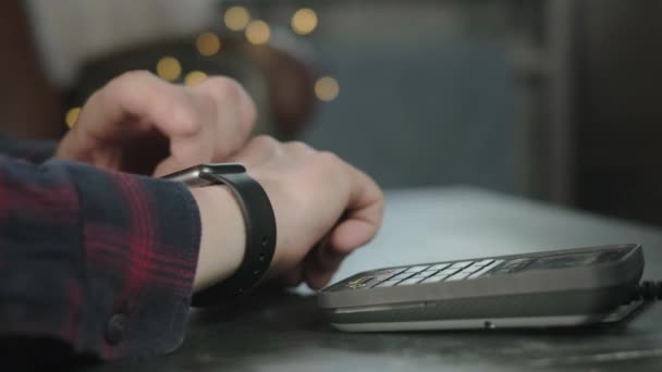 Un homme paie dans un café en utilisant une montre électronique intelligente. Technologie sans contact NFC. Achats en ligne utilisant la technologie moderne. Consommation internet achats en ligne. L'homme paie avec une montre intelligente — Video