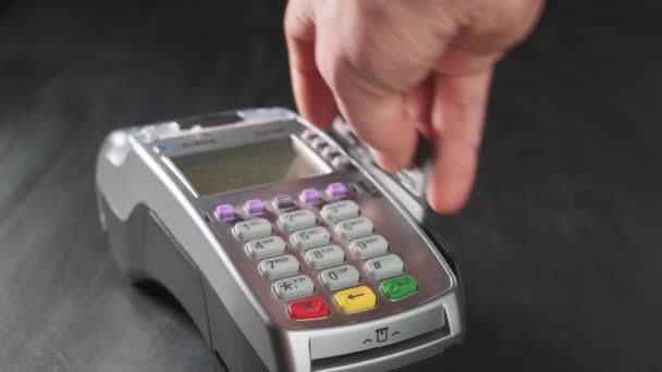 El usuario realiza el pago con tarjeta de crédito. Desliza el dedo hasta la terminal de pago sin efectivo. Mano de hombre con tarjeta de crédito deslizar a través de pos terminal. Servicios bancarios de dinero electrónico, transacciones . — Vídeos de Stock