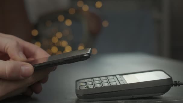 Fizetés telefonon a POS érintésmentes fizetési terminálon. A felhasználó okostelefonon keresztül vásárol egy boltban vagy étteremben. Elektronikus pénz készpénz nélküli pénztárcában — Stock videók
