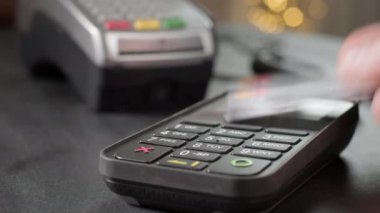 NFC teknolojisi. Banka terminalinde NFC çipi olan genç bir kadının yakın çekimi. Müşteri dışarıdan yemek siparişi veriyor. Müşteri el bilgileri erişimsiz kredi kartıyla ödenir..