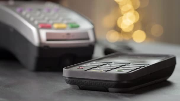 NFC-Technologie. Der Käufer bezahlt den Kauf kontaktlos mit einer Smartwatch. Drahtloses Bezahlen im Laden mit einem Gadget während einer Coronovirus-Pandemie. Existenzgründung für Kleinunternehmen — Stockvideo