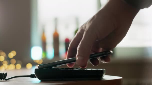 Pay by phone on the POS contactless payment terminal. A user makes a purchase using a smartphone in a store or restaurant. E-money at cashless wallet — Stock Video