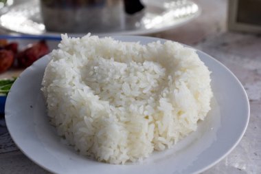 Bıçaklı beyaz bir masada sebzeli beyaz pirinç.