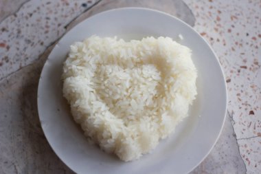 Masada pişmiş pirinç ve kalp şeklinde bir tabak var.