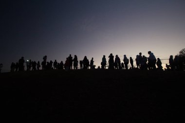 Kumsalda sırt çantalı bir adamın silueti.