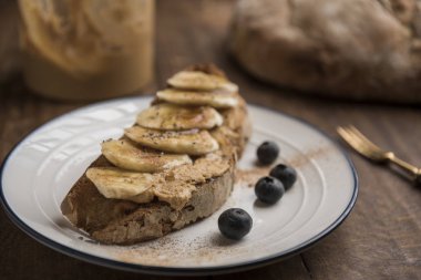 Kızarmış köy ekmeği, fıstık ezmesi ve muzlu vejetaryen kahvaltısı.