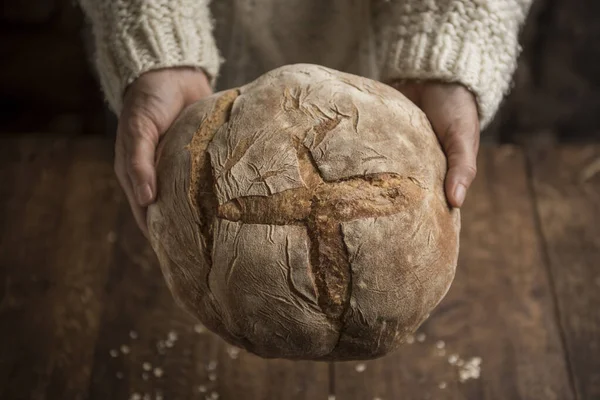 Dłonie kobiety trzymające świeżo upieczony chleb zakwaśny — Zdjęcie stockowe