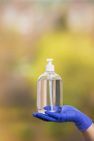 Coronavirus konsepti, ameliyat eldiveni olan kişi Coronavirus önleme için el dezenfektanı jeli gösteriyor. Salgın COVID 19. Boşluğu kopyala