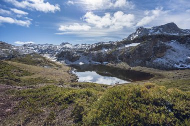 Laguna de Almagrera, Somiedo Doğa Parkı 'ndaki Saliencia gölleri, Asturias, İspanya. Dağlardaki karlı bölgelerde kışın sonu..