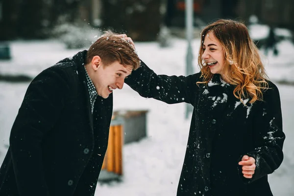 Casal brincando com neve e namorada jogando uma bola em férias de inverno — Fotografia de Stock