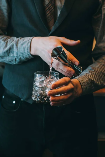 Genç barmen bir kokteyl yapıyor