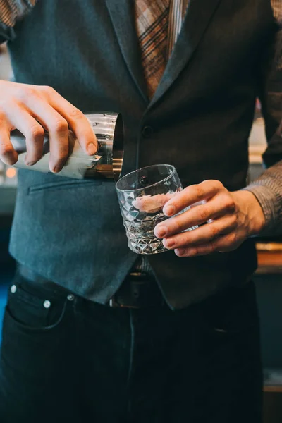 Genç barmen bir kokteyl yapıyor