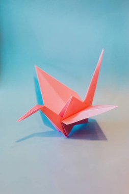 Işığa doğru uçan renkli Origami kuşlar.