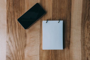 cep telefonu, eski ahşap masa üstünde defter