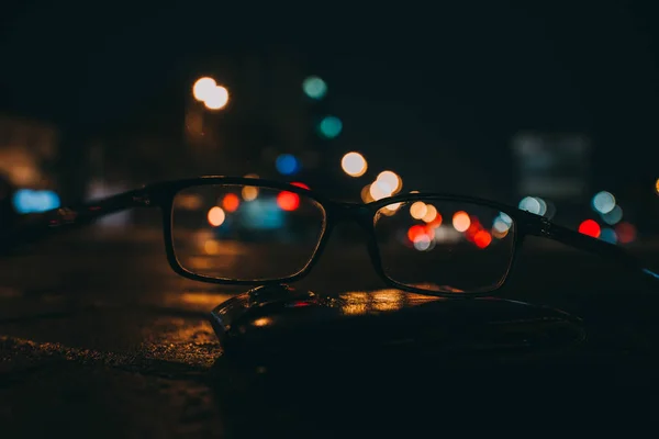 Paisaje nocturno con rascacielos y luces de la ciudad como se ve a través de un par de gafas. Imagen borrosa . —  Fotos de Stock