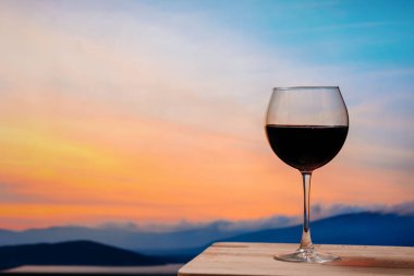 Gün batımına karşı kırmızı şarap, gökyüzünde bulutlu kırmızı şarap.