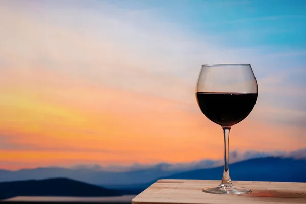 Gün batımına karşı kırmızı şarap, gökyüzünde bulutlu kırmızı şarap.
