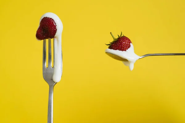 Çilekli ve ekşi kremalı Macro shot. Bir kaşıkta kırmızı böğürtlen. Sarı arkaplan