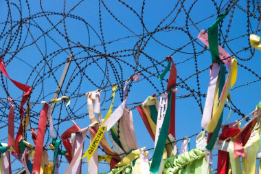 Ribbons tied at barbed wire at a fence at the demilitarised zone DMZ at the freedom bridge, South Korea, Asia clipart