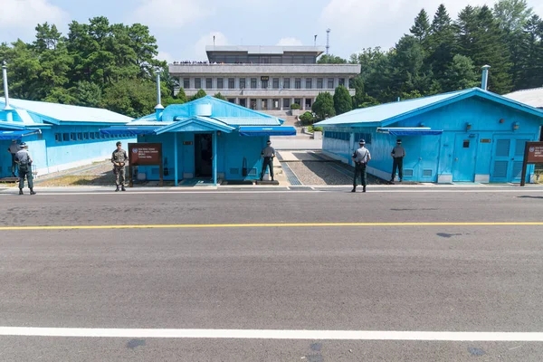 JSA all'interno di DMZ, Corea - 8 settembre 2017: 5 soldati delle Nazioni Unite e un soldato normale di fronte a edifici blu al confine nordcoreano con i turisti nordcoreani sullo sfondo dei Demilitari coreani — Foto Stock