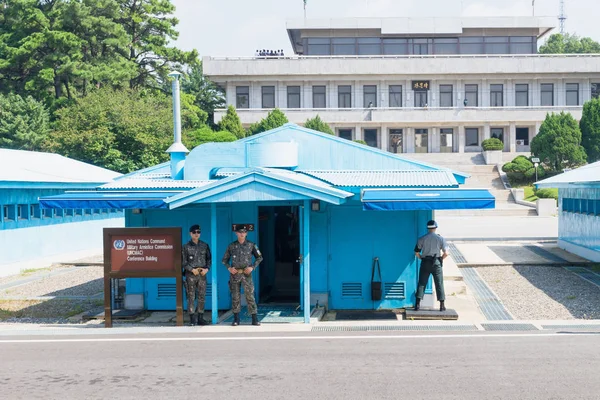 JSA dentro de DMZ, Corea - 8 de septiembre de 2017: Soldados y soldados de la ONU en ropa de camuflaje frente a edificios azules en la frontera de Corea del Norte con turistas norcoreanos en el fondo en Corea D —  Fotos de Stock