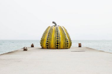Naoshima, Japan - September 29, 2017: Yayoi Kusama's pumpkin sculpture in front of the sea clipart