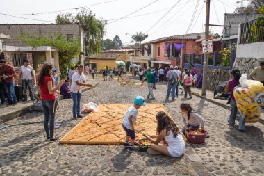 Alfombres, Arnavut kaldırımlı sokaklarda alayı San Bartolome de Becerra Antigua, Guatemala için renkli talaş tarafından yapılan halı üzerinde aile