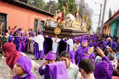 Mor kaftanlı adam İsa ve bir haç ile bir float San Bartolome de Becerra, Antigua, Guatemala alayı taşıyan